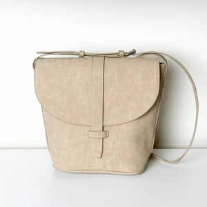 Väska Beige Åhléns - Beige väska som är lite större i botten och plattare upptill vid locket. Får plats med allt man behöver i den. Bra använt skick.