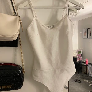 Vit body från Nelly Xs - Jätte fin tajt body från Nelly storlek xs. Använd fåtal gånger fin i skicket. Frakt ingår