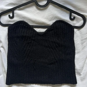 Svart ribbad tubtopp från Shein - Säljer en snygg svart ribbad tubtopp från Shein. Perfekt för en kväll ute eller som en del av en lager-på-lager-look. Toppen är i storlek S och har en tight passform som framhäver figuren.