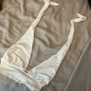 liten topp  - säljer denna kommer inte till användning.  fin vit topp som du knyter runt nacken 