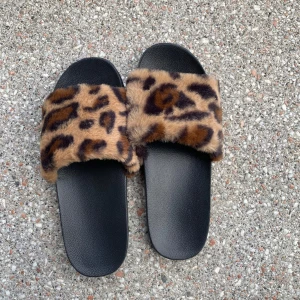 Leopard tofflor  - Tofflor med fluff i leopardmöster. Aldrig använda. Storlek 38/39