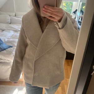 Beige Kappa - Jätte fin beige kappa från Vero Moda köpt förra året. Använd endast 1-2 gånger och är i nyskick. Perfekt nu till hösten. Nypris 799kr💗