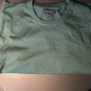 Mörkgrön Merinoull tröja  - Säljaren denna fräscha och ganska oanvända Knirwear ifrån Riley. Tröjan är i 100% merinoull och storlek M.