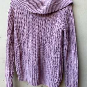 Ljuslila stickad tröja från KappAhl - Säljer en superfin rosa stickad tröja från KappAhl. Den har en mysig polokrage och är perfekt för kyliga dagar. Tröjan är långärmad och har en ribbad struktur som ger den en extra touch. Perfekt för höst och vinter!