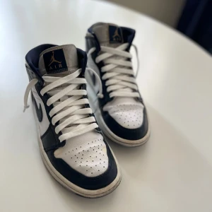 Air Jordan 1 Mid (Str 41) - Hej, jag säljer ett par fina Jordans. Dem sitter bra och är sköna.  Ingår en box och ett par mörkblåa snören. Pris kan diskuteras vid snabb affär.