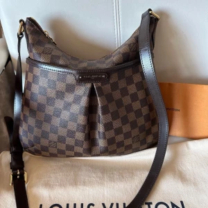 Louis Vuitton blommsbury pm - Louis Vuitton bloomsbury pm i fint skick . På framsida finns ett stort ficka med magnetisk stängning. Väskan kan användas som crossbody eller axelväska, stängs med dragkedja. Justerbar axelrem. Datecode: DU4121 Storlek: 33x29x3 cm. Väskan skickas med