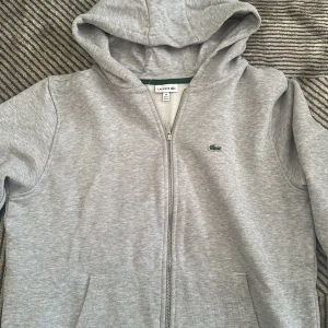 Hoodie från Lacoste - Hoodie för barn från Lacoste i storlek 16, passar någon som är 176 cm lång ungefär. I nyskick! 