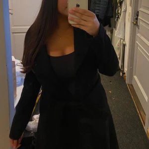 Kappa - Jättefin lång svart kappa från zara i bra skick perfekt till hösten. Ca 90 cm lång, ungefär till knäna på mig som är 165 cm