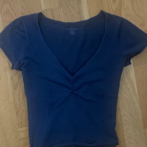 Mörkblå t shirt - Supersöt mörkblå urringad t shirt💗Köpt på brandy Melville, super skick, endast använd några få gånger💗som ny💗köpt för 200kr