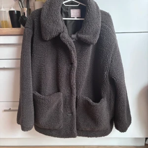 Teddy höstjacka / vinterjacka - Jättesnygg oversized vindtät teddyjacka i brun färg. Passar bra i höst men har även haft den som vinterjacka i Umeå = den klarar rejäl kyla. Smidiga fickor på framsidan plus ficka med dragkedja på insidan.