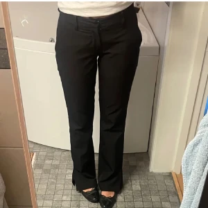 Kostymbyxor från Bik Bok - Svarta lågmidjade kostymbyxor från Bik Bok med slits längst ner som inte längre säljs. Dem är i storlek 36 men passar även mig jätte bra som egentligen har storlek 34💞