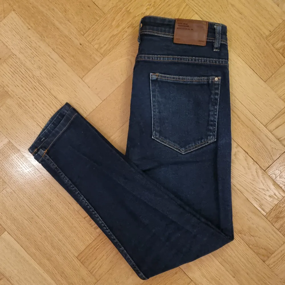 Ett par klassiskt mörkblå jeans. 98% bomull och 2% elastan. Fickor fram och bak. Knäppning på framsidan med dragskedja och knapp. Blivit något blekta på sina ställen, men annars bra skick. Skinny fit. . Jeans & Byxor.