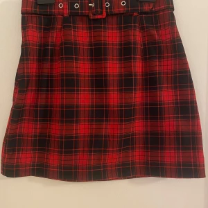 Rutig mnikjol  - Minikjol med reglerbar skärp. St S men passar för XS.