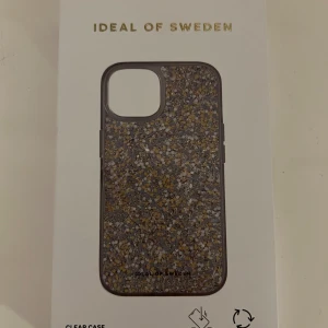 Glittrigt mobilskal från IDEAL OF SWEDEN - Snyggt och glittrigt mobilskal från IDEAL OF SWEDEN. Perfekt för att ge din telefon en extra touch av stil och skydd. Skalet har en glittrig design som verkligen sticker ut och är både trendigt och funktionellt.