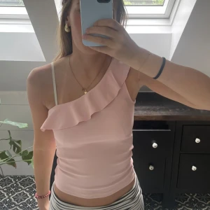 One shoulder volang topp - Säljer min jättesöta volangtopp som är one shoulder! Köptes utomlands på stradivarius för 250kr och tror inte att den finns i Sverige. Använd en gång och är i nyskick💓💓