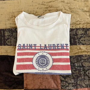 Saint Laurent t-shirt - Intressekoll🚨Köpt från Vesitaire för 3k finns inga kvar att köpa, slitningarna kom med plagget oklar ifall det är nyskick. Imo slitningarna är snygga då de ger karaktär, inga hål överhuvudtaget. Skriv vid minsta lilla fråga!