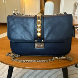 Valentino Glam Lock Crossbody - Valentino Glam Lock Crossbody väska i marinblå! Köpt ny på vestiare för 8900 och har använts väldigt sparsamt. Har äkthetsbevis, dustbag och kvitto. Hör av er för fler bilder🥰