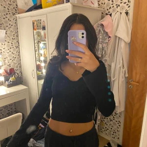 Svart croppad långärmad topp - Säljer en svart gina croppad topp med utsvängda långa ärmar. Toppen är tight och har en stilren design som passar till det mesta.