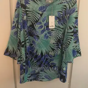 Blus i polyester. Aldrig använd, prislapp kvar.