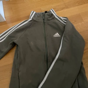 Grön adidas kofta  - En grön adidas tröja i storlek S men passar även till storlek M. Slutat använda men användt den ett bra tag 