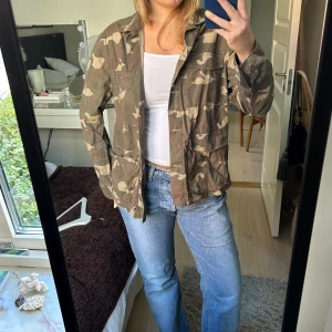 Militärmönstrad jacka - Tunn jacka med militärmönster, fyra fickor på framsidan och knappar och med krage