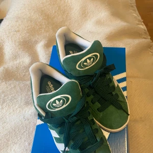 Gröna Adidas campus 00s - Skorna är helt nya, endast använda en gång då jag testade dem. Säljer skorna då dem var för små för mig. Kartongen är trasig då jag råka trampa på den, dock bara en sida/ett hörn!! 