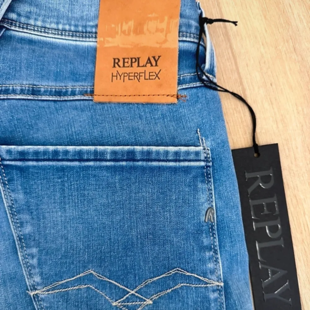 Säljer ett par snygga blå jeans från Replay Hyperflex. De är i modellen Anbass med slim fit passform. Jeansen har en klassisk femficksdesign och är tillverkade i ett stretchigt material för extra komfort. Perfekta för både vardag och fest!. Jeans & Byxor.