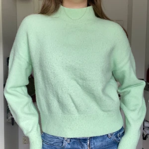 Mintgrön stickad tröja - Ljust mintgrön stickad tröja från &otherstories. Lite halvpolo, superskönt på vintern! Har blivit lite nopprig men det kan man enkelt raka bort med rakhyvel, annars i fint skick!