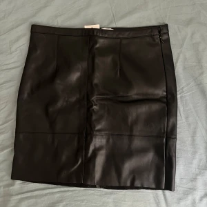 Skinnkjol stl 36 - Säljer snygg skinnkjol i PU-läder från Cubus i storlek 36. Jag köpte den själv second hand, därav den halva prislappen. Aldrig använd eller testad av mig. Osynlig dragkedja i sidan.  Hör gärna av er för fler bilder eller frågor 😊