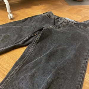 Svarta Big boy jeans  - Väl andvända men inga skador eller slitage i tyget. Urtvättad svart färg med orange bruna sömmar. Mått: ben 71cm midja 40cm från midja till byx öppning 102cm