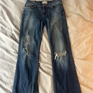Lågmidjade bootcutjeans med hål  - Jättesnygga lågmidjade bootcutjeans med hål, lite slitna där nere annars i jättebra skick! 