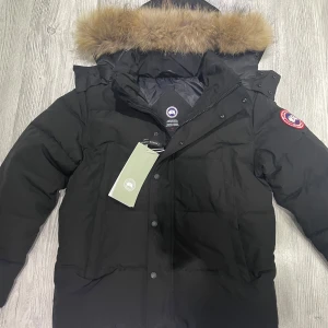 Canada Goose jacka - Hej! Säljer en svart dunjacka från Canada Goose i mycket bra skick den är nästan ny jag har inte andvänd den så mycket eftersom den ej matcha min stil. Jackan har en avtagbar huva med päls. Perfekt för den kalla vintern jackan är i S men passar även som M original tillbehören ingår med jackan, priset kan diskuteras så hör av dig vid minska lilla fundering👍