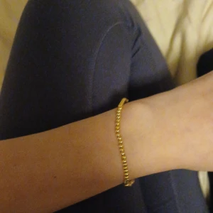 Guldarmband - Snyggt och enkelt guldarmband som passar perfekt till både vardag och fest. Armbandet har en klassisk kedjedesign och är lätt att matcha med andra smycken. Perfekt för att ge en touch av elegans till vilken outfit som helst.