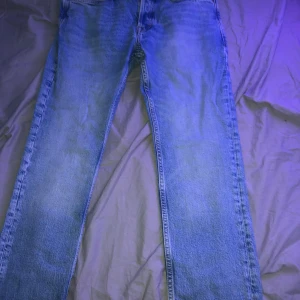 Blå jeans från Jack & Jones - Säljer ett par snygga blå jeans från Jack & Jones i modellen Slim Straight/Tim. De har en klassisk femficksdesign och är i bra skick. Perfekta för både vardag och fest! Passar till det mesta och är superbekväma.