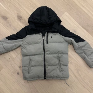 Grå och svart dunjacka från Ralph Lauren - Säljer nu en riktigt fin jacka från ralph lauren som är perfekt nu för det kalla vädret. Jackan har använts ganska mycket men ingenting är fel med den 9/10 skick. Nypris: 2999 Storlek XS/S. Pris går att diskutera lite