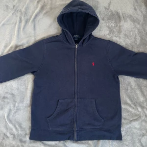 Mörkblå ziphoodie från Polo Ralph Lauren - Säljer mörblå ziphoodie från Polo Ralph Lauren, den är i gott skick och har inga synliga defekter.    Är egentligen i storlek (18-20) XL men sitter precis som en XS eller S Nypris-1500
