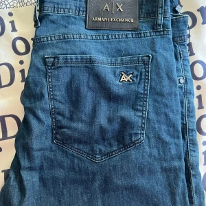 Blå jeans från Armani Exchange - Säljer ett par snygga blå jeans från Armani Exchange i storlek 36. De är tillverkade av 98% bomull och 2% lycra, vilket ger en skön stretch. Perfekta för både vardag och fest! 💙