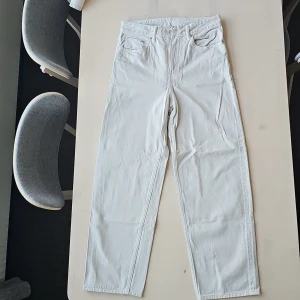 Vita loose fit byxor från H&M - Säljer ett par vita loose fit byxor från H&M i storlek 28/32. De är i bra skick och perfekta för en avslappnad stil. Byxorna har en klassisk design med fickor och knappar. Perfekta för både vardag och chill dagar! 🤍