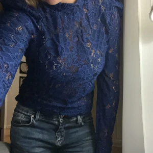 Blå spetsblus - Säljer en superfin blå spetsblus med långärmad design. Perfekt för både vardag och fest! Blusen har ett vackert blommönster och är i mycket bra skick!💕💕