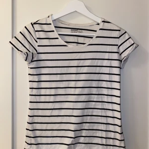 Randig t-shirt från Basic - Säljer en klassisk vit och svart randig t-shirt från Basic. Den är kortärmad och perfekt för en avslappnad stil. Materialet känns mjukt och bekvämt, idealiskt för vardagsbruk. Passar bra till jeans, kjol eller shorts. Liten i storleken! Pris kan diskuteras 