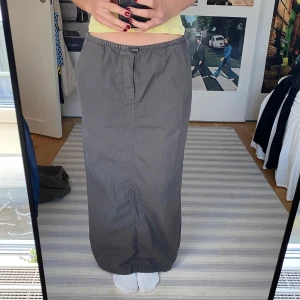 Mörkgrå cargokjol  - Mörkgrå cargokjol från Zara i mycket bra skick. Kjolen har en slits baktill och elastisk midja som man kan justera. Finns ficka på vardera sida. Jag är 167 cm lång. 