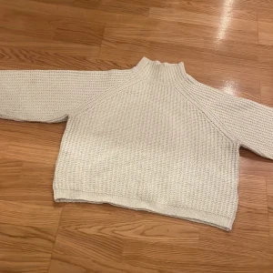 Vit stickad polotröja - Mysig vit stickad polotröja perfekt för kyliga dagar. Den har en hög krage och långa ärmar som håller dig varm. Tröjan är i bra skick och passar perfekt till både vardag och mysiga hemmakvällar. Ett måste i garderoben för höst och vinter!