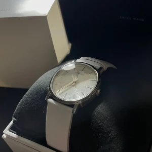 Vit klocka Calvin Klein - Säljer en fin Calvin Klein damklocka med vitt armband och silverfärgad urtavla. Klockan är i gott skick och har aldrig använts. Den är vattentät och har ett kvartsurverk. Klockan kommer i originalförpackning med bruksanvisning.