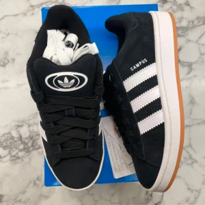 Adidas Campus 00s Black Gum - Helt nya och oanvända Adidas Campus 00s ”Black Gum” i Juniormodellen. Storlek: 38. Pris: 899. Skicka ett meddelande vid intresse. Köp tryggt och snabbt hos oss. Många nöjda kunder😊