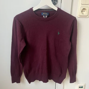 Vinröd tröja från Polo Ralph Lauren - Säljer en snygg vinröd tröja från Polo Ralph Lauren i storlek 14-16 år.  Perfekt för både höst och vinter, och den är i bra skick. Hund i hemmet. 