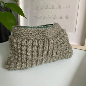 Virkad necessär  - Superfin virkad necessär med bubblig textur. Perfekt julklapp till mamma, kompis, syskon, passar till alla! Insidan är fodrad med ett ljust tyg som ger en fin kontrast. Perfekt för smink, småsaker eller som en söt detalj i badrummet! Egengjord 🧶