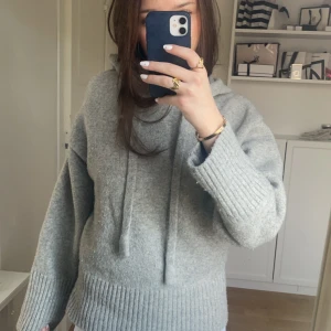 Stickad hoodie från Zara - Säljer denna populära hoodie från Zara som inte finns på hemsidan längre. Storlek M men men passar perfekt på mig som vanligtvis bär S. Den är stickad med huva och ribbade muddar vid ärmslut och nederkant🩶Den är lite nopprig på vissa ställen men annars verkligen jättebra skick💕💕PRIS GÅR ATT DISKUTERA!