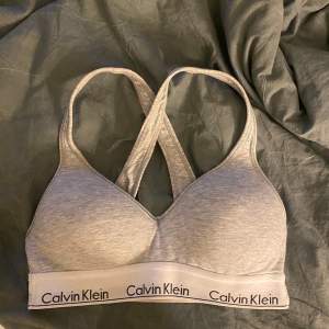 Säljer en grå topp från Calvin Klein i mycket bra skick. Den är tillverkad i mjuk bomull och har ett elastisk underband🤩🤩 Sååå bekväm och väldigt snygg! Använd ett fåtal gånger och säljer pga att den är för liten 