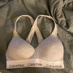 Grå topp från Calvin Klein - Säljer en grå topp från Calvin Klein i mycket bra skick. Den är tillverkad i mjuk bomull och har ett elastisk underband🤩🤩 Sååå bekväm och väldigt snygg! Använd ett fåtal gånger och säljer pga att den är för liten 