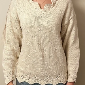 Beige stickad tröja med spetsdetaljer - Säljer en superfin beige stickad tröja med v-ringning och spetsdetaljer vid halsen och nederkanten. Perfekt för höst och vår! Tröjan har långa ärmar och ett diskret mönster som ger den en unik touch. 